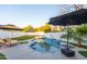 Beautiful pool area featuring a rock waterfall feature, lounge chairs, and umbrellas for shade, creating a private retreat at 2226 E Parkside Ln, Phoenix, AZ 85024