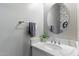 Charming powder room features a white vanity with a marble countertop and round mirror at 23065 N 75Th St, Scottsdale, AZ 85255