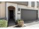 Close-up of a townhome's entrance with an attached garage and desert landscaping at 23065 N 75Th St, Scottsdale, AZ 85255