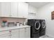 Well-organized laundry room with modern machines, white cabinets, and marbled countertops at 23065 N 75Th St, Scottsdale, AZ 85255