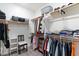 Spacious walk-in closet featuring custom shelving, multiple hanging rods, and hardwood flooring at 23065 N 75Th St, Scottsdale, AZ 85255