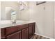 Bathroom vanity features dark wood cabinets, white countertops, and large mirror with lighting at 2402 E 5Th St # 1403, Tempe, AZ 85288