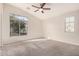 Bright bedroom features a large window, ceiling fan and neutral carpet and paint at 2402 E 5Th St # 1403, Tempe, AZ 85288