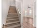 Carpeted staircase with white railing leading to the upper level, next to a spacious room with hard wood floors at 2402 E 5Th St # 1403, Tempe, AZ 85288