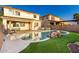 The refreshing pool features a rock waterfall and is surrounded by lush artificial grass at 26312 N 132Nd Ln, Peoria, AZ 85383