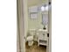 Cozy half bath featuring a white vanity, toilet, and oval mirror; window provides natural light at 26312 N 132Nd Ln, Peoria, AZ 85383