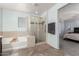 Bright bathroom with a soaking tub, a tiled walk-in shower, and a view into the bedroom at 26312 N 132Nd Ln, Peoria, AZ 85383