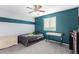 Comfortable carpeted bedroom with a ceiling fan and color blocked accent wall at 26312 N 132Nd Ln, Peoria, AZ 85383