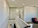 Well-lit upstairs hallway featuring white railing, multiple doorways, and neutral carpeting at 26312 N 132Nd Ln, Peoria, AZ 85383