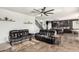 Open-concept living room with leather sofas, tile flooring, and a view of the kitchen featuring an island and modern appliances at 26312 N 132Nd Ln, Peoria, AZ 85383