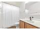 Cozy bathroom with wood vanity, sink, toilet, mirror, and shower with white curtain at 3147 E Michigan Ave, Phoenix, AZ 85032