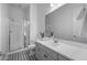 Well-lit bathroom with glass enclosed shower, gray vanity and black and white tile floor at 3539 E Starflower Dr, Queen Creek, AZ 85142