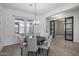 Bright dining room featuring stylish lighting, seating for six, and elegant tile flooring at 3539 E Starflower Dr, Queen Creek, AZ 85142