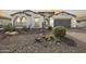 Charming stucco home featuring desert landscaping, a gray garage door and beautiful arched windows at 3539 E Starflower Dr, Queen Creek, AZ 85142