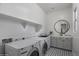 Well-lit laundry room featuring modern washer and dryer, sleek countertop and a decorative mirror at 3539 E Starflower Dr, Queen Creek, AZ 85142