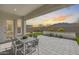 Covered patio featuring an outdoor dining set and a view of the landscaped backyard and desert mountains at 3539 E Starflower Dr, Queen Creek, AZ 85142