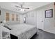 Bright bedroom featuring a large bed, ceiling fan, modern decor, and an ensuite bathroom at 3553 N 292Nd Dr, Buckeye, AZ 85396