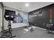 Home gym featuring exercise bike, weight bench, weights, inspirational wall art, and rubber flooring at 3553 N 292Nd Dr, Buckeye, AZ 85396