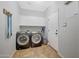 Functional laundry room with modern washer and dryer, storage cabinets, and tile flooring at 3553 N 292Nd Dr, Buckeye, AZ 85396