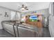 Open living room featuring dark wood floors, ceiling fan, large tv and a plush leather sofa at 3553 N 292Nd Dr, Buckeye, AZ 85396