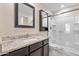 Bathroom featuring granite countertops, dark wood cabinetry, and a walk-in shower at 3911 S 79Th Ln, Phoenix, AZ 85043