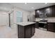 Spacious kitchen featuring an island, stainless appliances, tile floors and dark wood cabinets at 3911 S 79Th Ln, Phoenix, AZ 85043