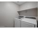 Laundry room features modern washer and dryer and a storage shelf at 3911 S 79Th Ln, Phoenix, AZ 85043