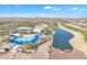 An aerial view showcasing a resort-style pool, clubhouse, and golf course with a scenic lake at 3956 N San Marin Dr, Florence, AZ 85132