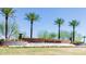 Elegant 'Sun City Anthem at Merrill Ranch' entrance sign framed by palm trees against a clear blue sky at 3956 N San Marin Dr, Florence, AZ 85132