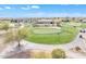 Aerial view of a meticulously maintained green golf course with golfers, carts, and surrounding desert homes at 3956 N San Marin Dr, Florence, AZ 85132