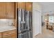 Stainless steel refrigerator with wood cabinets and white subway tile in the kitchen at 3956 N San Marin Dr, Florence, AZ 85132