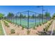 Outdoor tennis courts are enclosed by a tall fence and bordered by landscaping and offer a great amenity for residents at 3956 N San Marin Dr, Florence, AZ 85132