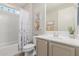 Bright bathroom featuring a shower-tub combo with floral shower curtain, large mirror, and neutral colored vanity at 4107 N Hawthorn Dr, Florence, AZ 85132