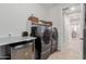 This laundry room features stainless steel washer and dryer, white cabinets and drawers, and tiled floors at 4107 N Hawthorn Dr, Florence, AZ 85132