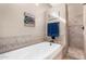 Well-lit bathroom featuring a soaking tub, a separate shower stall, and tile accents at 4217 E Edgemont Ave, Phoenix, AZ 85008