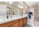 Bright bathroom with double sinks, a vanity with ample storage space, and a framed glass shower at 4217 E Edgemont Ave, Phoenix, AZ 85008