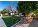 Well-maintained front yard with lush green lawn, mature trees, and attractive landscaping leading to the home's entrance at 4217 E Edgemont Ave, Phoenix, AZ 85008