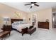 Comfortable main bedroom featuring a ceiling fan, ensuite bathroom, and decorative wall art at 4217 E Edgemont Ave, Phoenix, AZ 85008