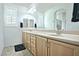 Bright bathroom with double sinks, wood cabinetry, tiled flooring and mirrors at 4424 N Potomac Dr, Florence, AZ 85132