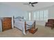 Light-filled bedroom with a ceiling fan, a wooden bed frame, dressers and an accent chair at 4424 N Potomac Dr, Florence, AZ 85132