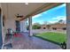 A covered patio with ceiling fan, pavers, and a manicured yard at 4424 N Potomac Dr, Florence, AZ 85132