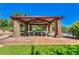 Covered picnic area with multiple tables and seating, surrounded by trees and grassy lawn at 4424 N Potomac Dr, Florence, AZ 85132