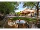 Expansive backyard featuring a covered patio, outdoor seating, a fire pit, and mature trees at 4741 W Kristal Way --, Glendale, AZ 85308