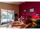 Inviting living room featuring a red accent wall, tile floors, and access to the backyard at 4741 W Kristal Way --, Glendale, AZ 85308