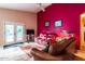 Spacious living room featuring red accent wall, tile floors, and sliding door access to the backyard at 4741 W Kristal Way --, Glendale, AZ 85308