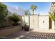 A well-maintained backyard featuring a variety of plants, trees, and storage sheds on a brick-paved ground at 5110 N 78Th St, Scottsdale, AZ 85250