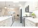 Contemporary kitchen with stainless steel appliances, white cabinets, and a view into the living area at 5110 N 78Th St, Scottsdale, AZ 85250