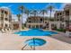 Community pool and hot tub area lined with palm trees and lounge chairs at 5303 N 7Th St # 114, Phoenix, AZ 85014