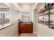 Inviting wet bar with a sink, cherry cabinets, window view, and industrial style shelving at 5331 N Pajaro Ct, Litchfield Park, AZ 85340