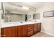 Bathroom featuring a double vanity with wood cabinets and a large mirror at 5331 N Pajaro Ct, Litchfield Park, AZ 85340